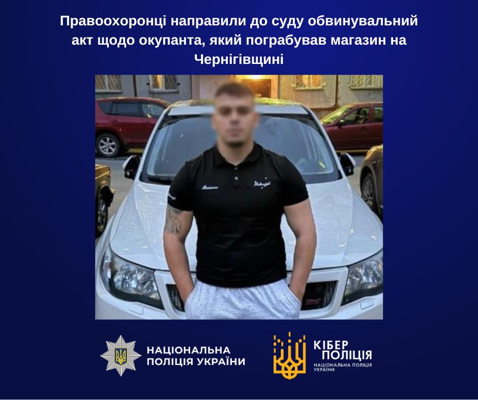Інформаційне зображення на темно-синьому тлі, у верхній частині якого білим текстом розміщено заголовок: Правоохоронці направили до суду обвинувальний акт щодо окупанта, який пограбував магазин на Чернігівщині. У центрі розміщено квадратне фото чоловіка у чорній футболці-поло та сірих спортивних штанях, який тримає руки в кишенях і стоїть на тлі білого автомобіля, припаркованого на вулиці біля будинку. Обличчя чоловіка повністю розмите, а на його правій руці видно татуювання. У нижній частині зображення розташовані два білі логотипи: ліворуч — Національна поліція України із зображенням зірки та тризуба, праворуч — Кіберполіція Національної поліції України із жовто-білим логотипом.
